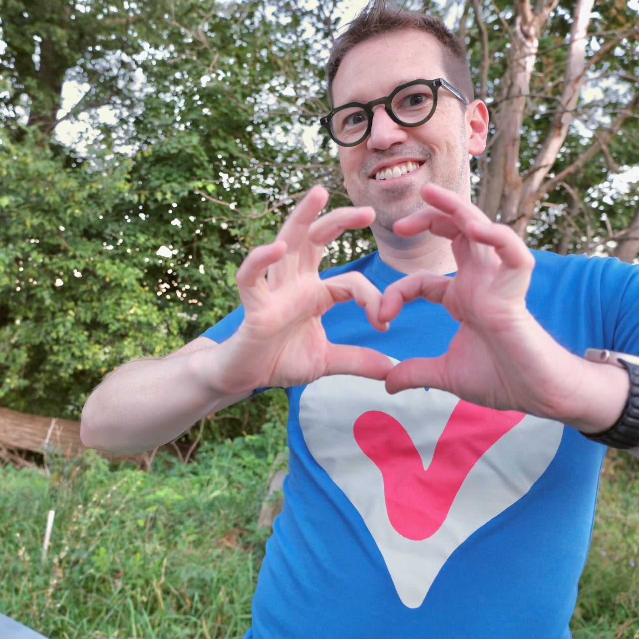 A photo of Jedd making a heart with his hands