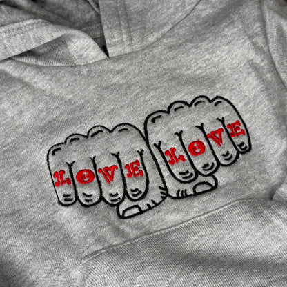 Detail of a design of two fists together that read Love Love