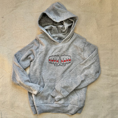 A youth size gray hoodie with a design that reads Love Love