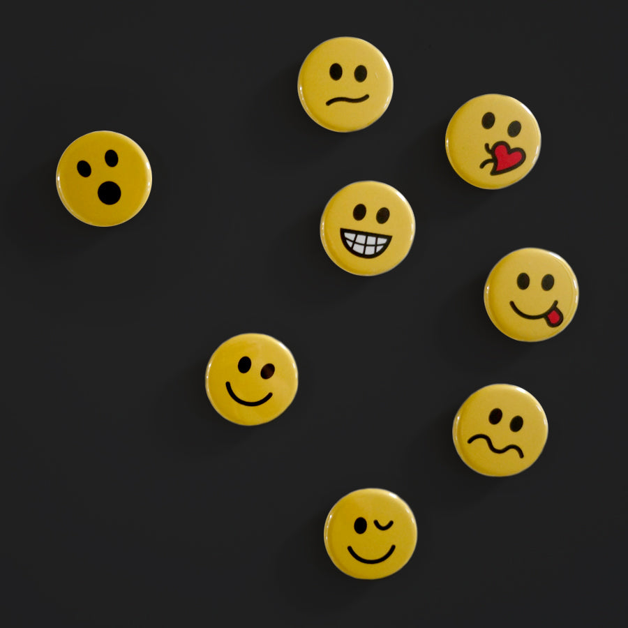 A collection of small pin magnets with different emotional faces